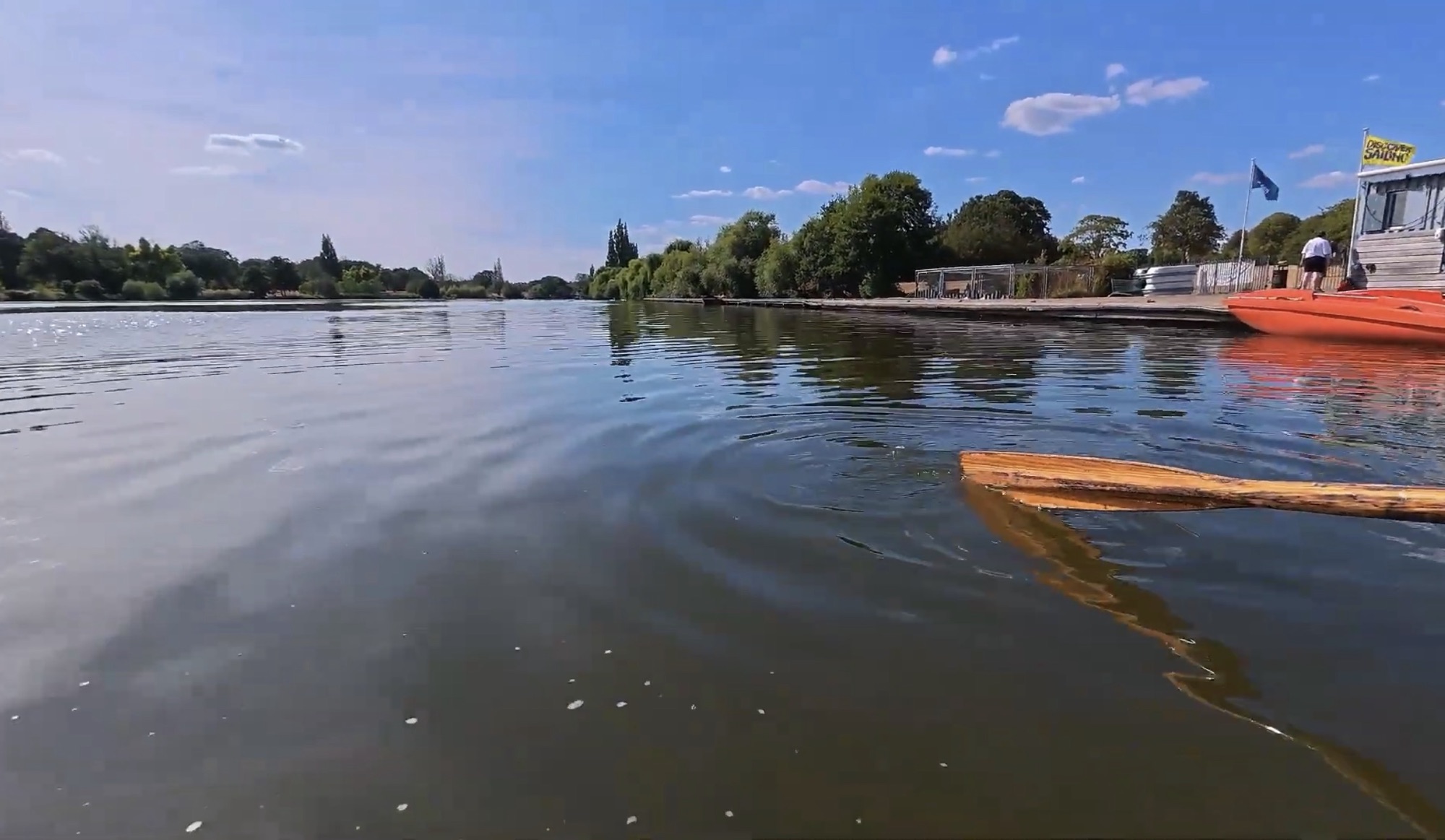 View across Danson Park lake from a rowboat with an oar in the water
