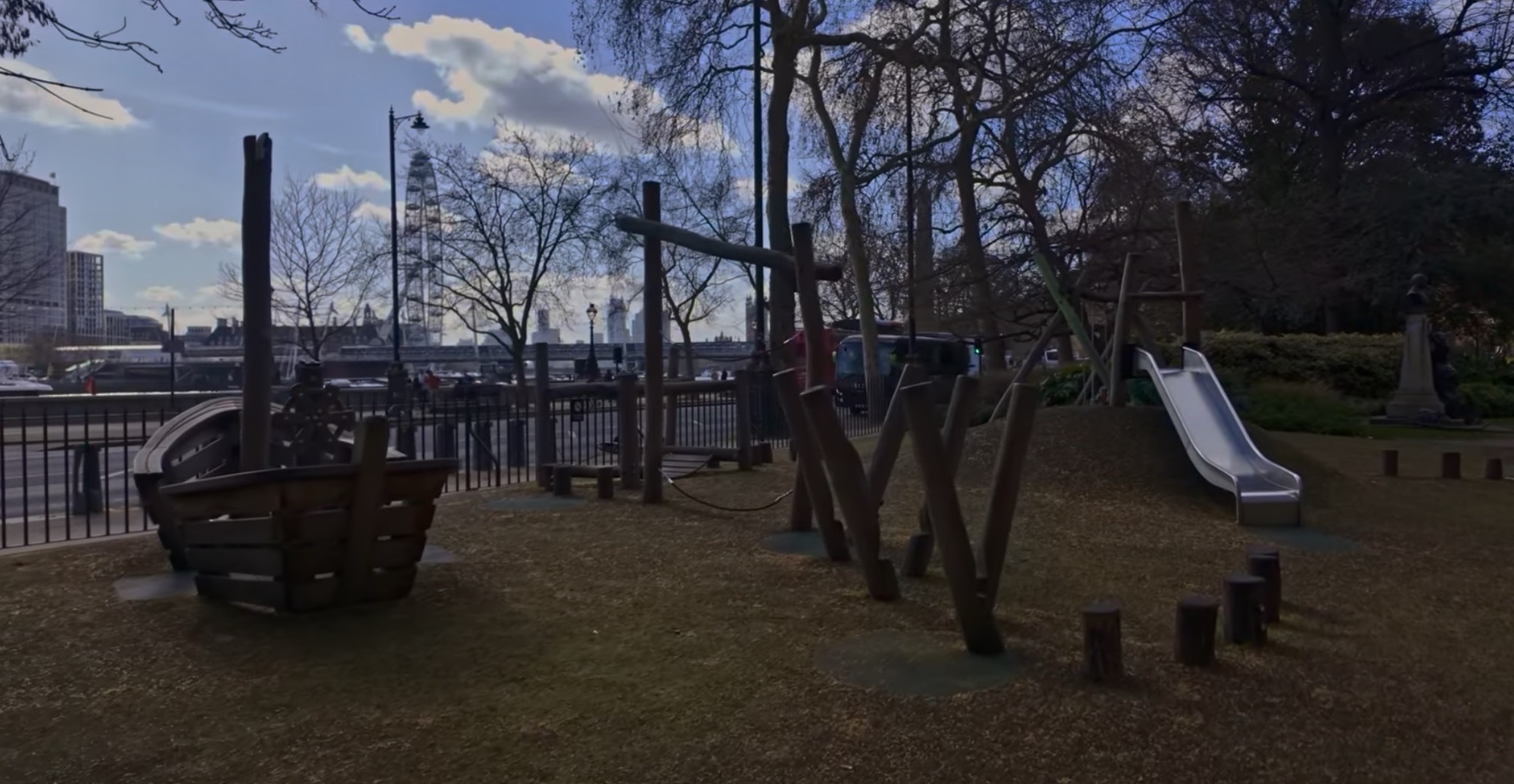 Timber play area with a wooden boat structure and slide, with the London Eye visible in the background