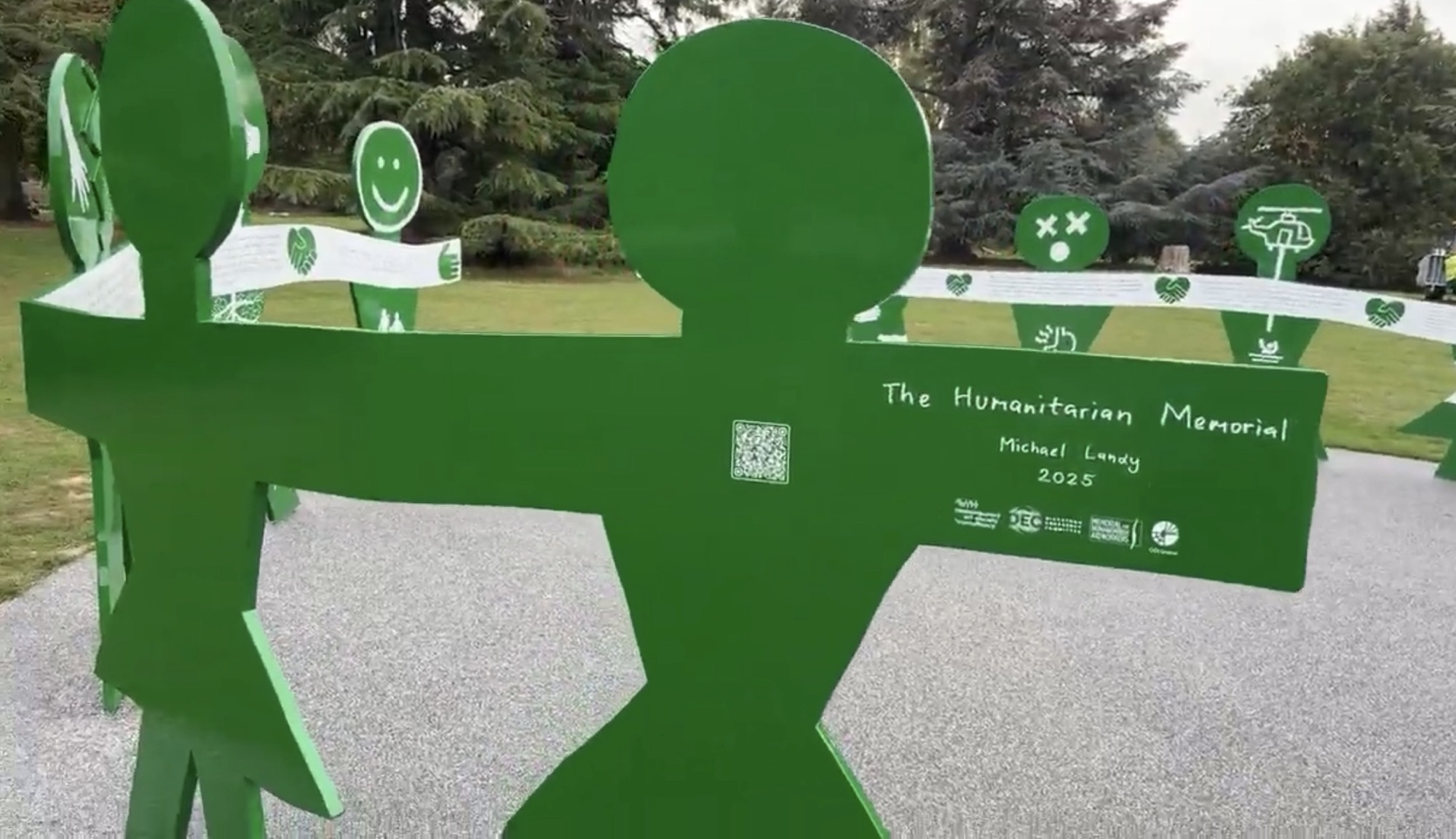 The Humanitarian Memorial by Michael Landy, green figures with outstretched arms in Gunnersbury Park