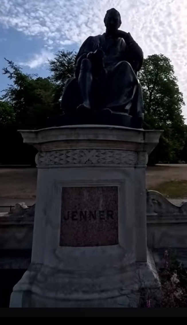 Seated bronze statue of Edward Jenner on its stone pedestal inscribed Jenner, in Kensington Gardens