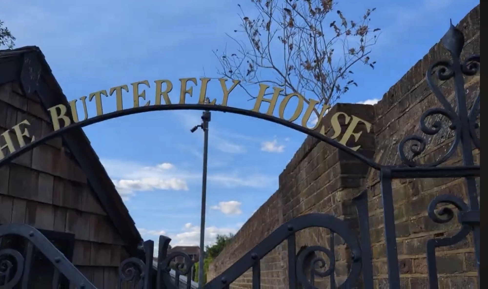 Wrought iron archway reading The Butterfly House at an entrance gate in Golders Hill Park
