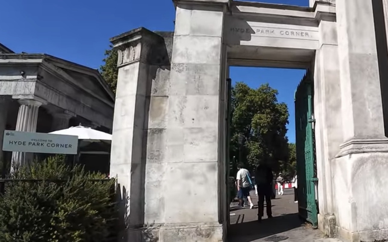 Stone archway entrance reading Hyde Park Corner, with a Welcome to Hyde Park Corner sign beside it