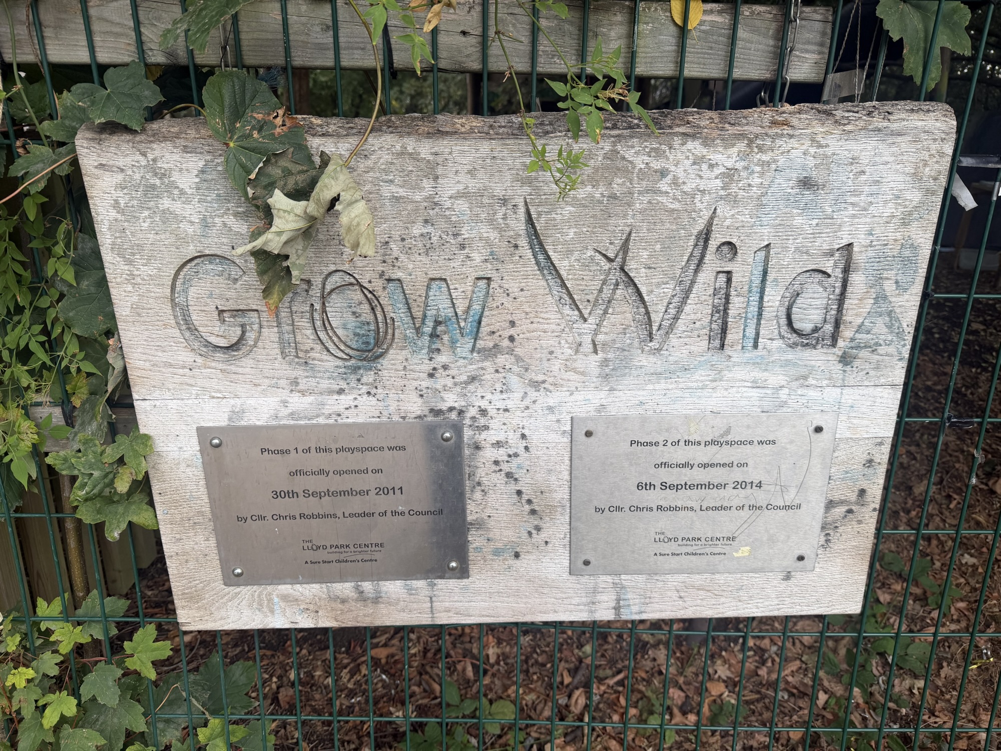 Grow Wild playspace sign at Lloyd Park with plaques marking the phase 1 and phase 2 opening dates