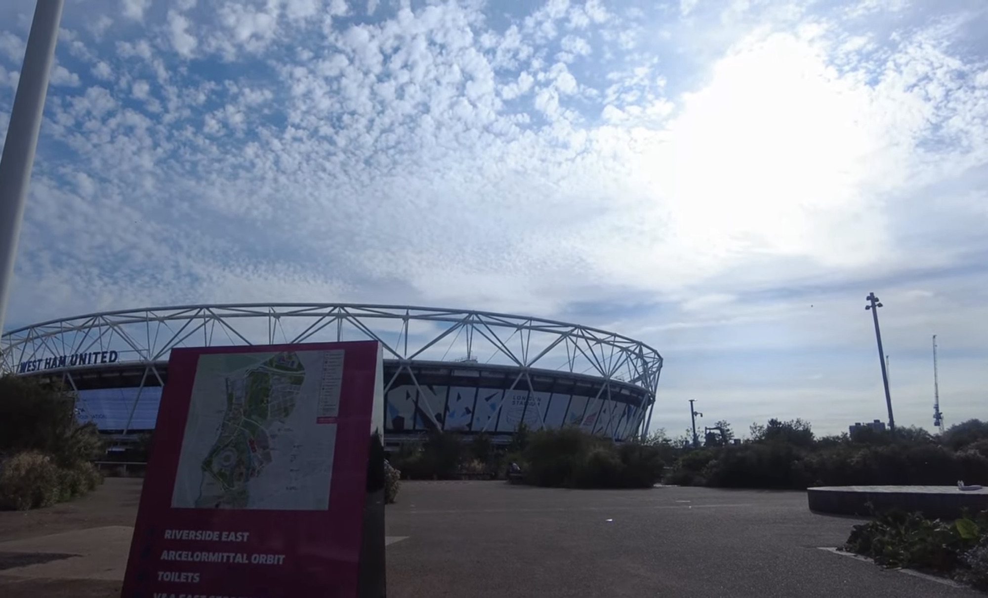 London Stadium, home of West Ham United, seen behind a park map board in Queen Elizabeth Olympic Park