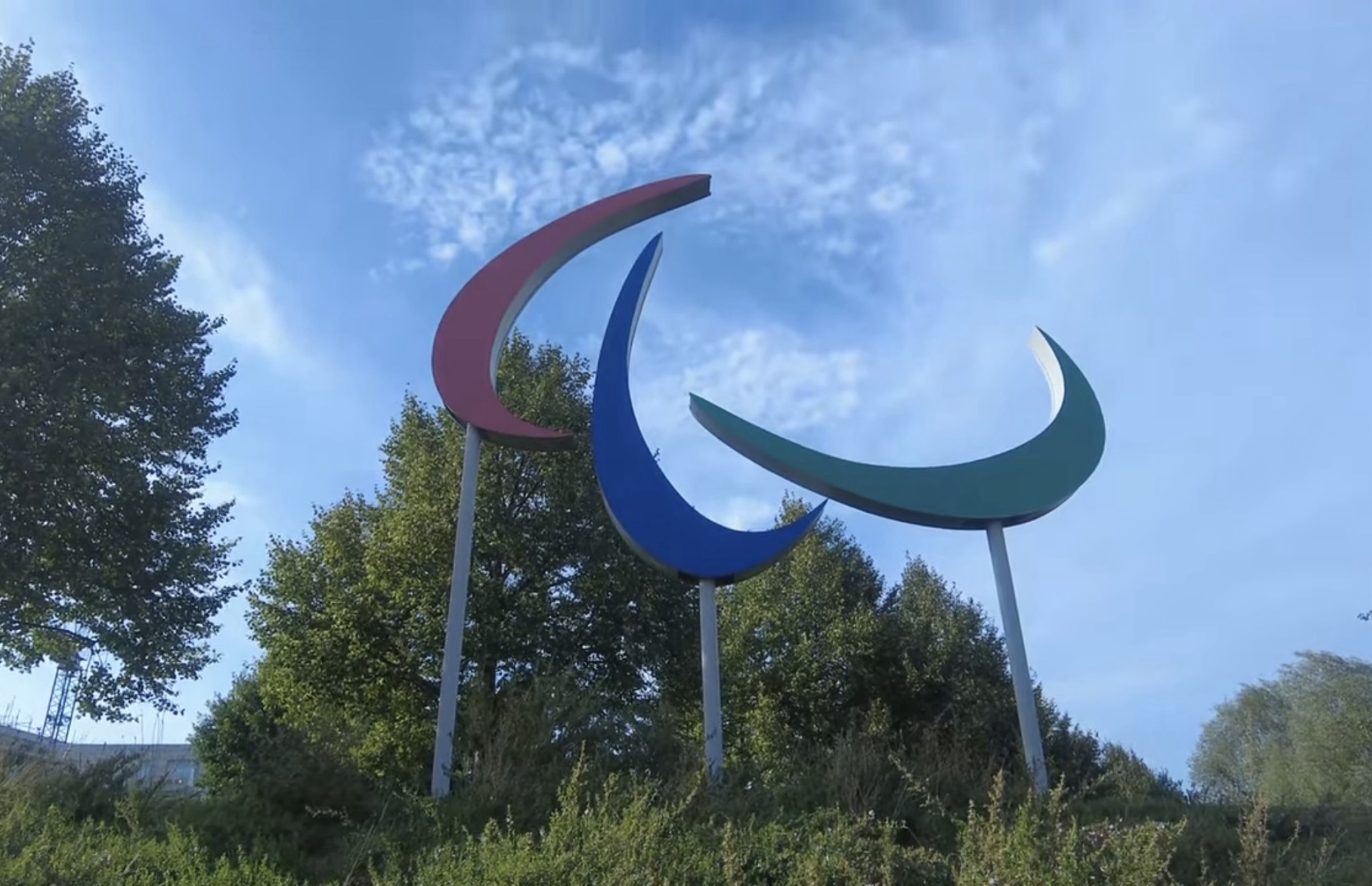 Three coloured Agitos sculpture representing the Paralympic Games symbol against a blue sky in Queen Elizabeth Olympic Park