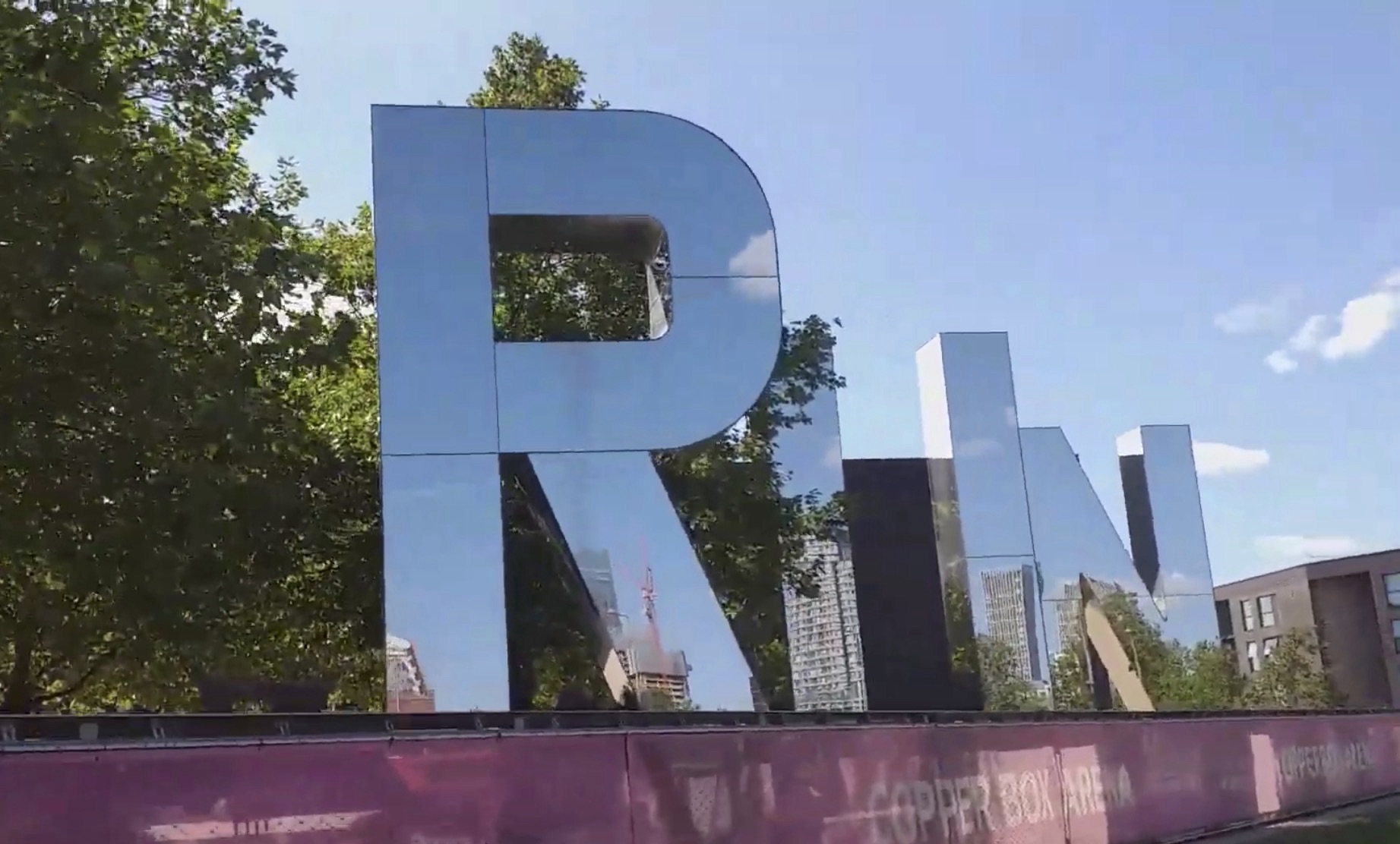 Giant mirrored PRINT letters sculpture reflecting the sky and Stratford skyline near Copper Box Arena in Queen Elizabeth Olympic Park