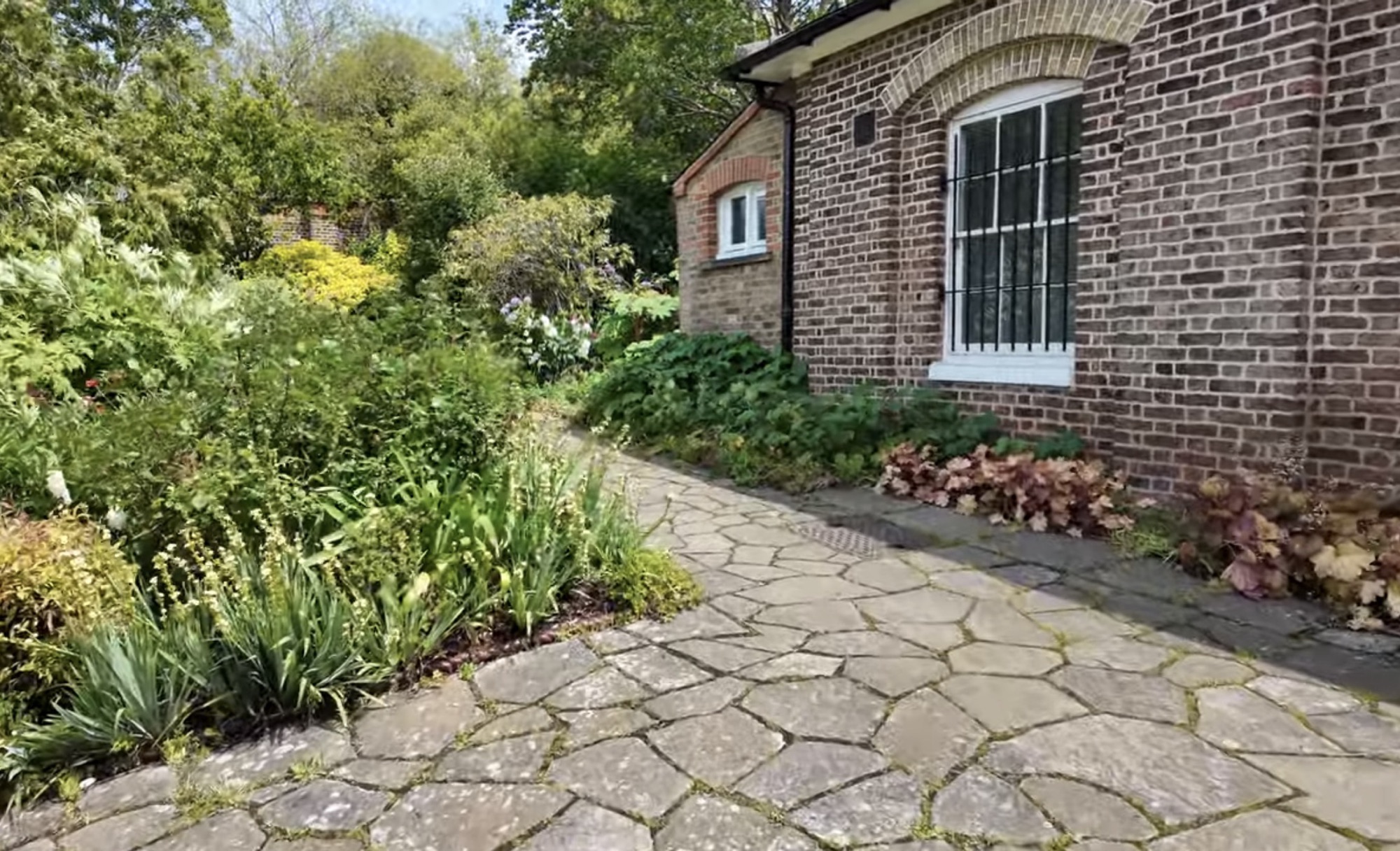 Stone path leading past the brick Temple building beside the Walled Garden in Brockwell Park
