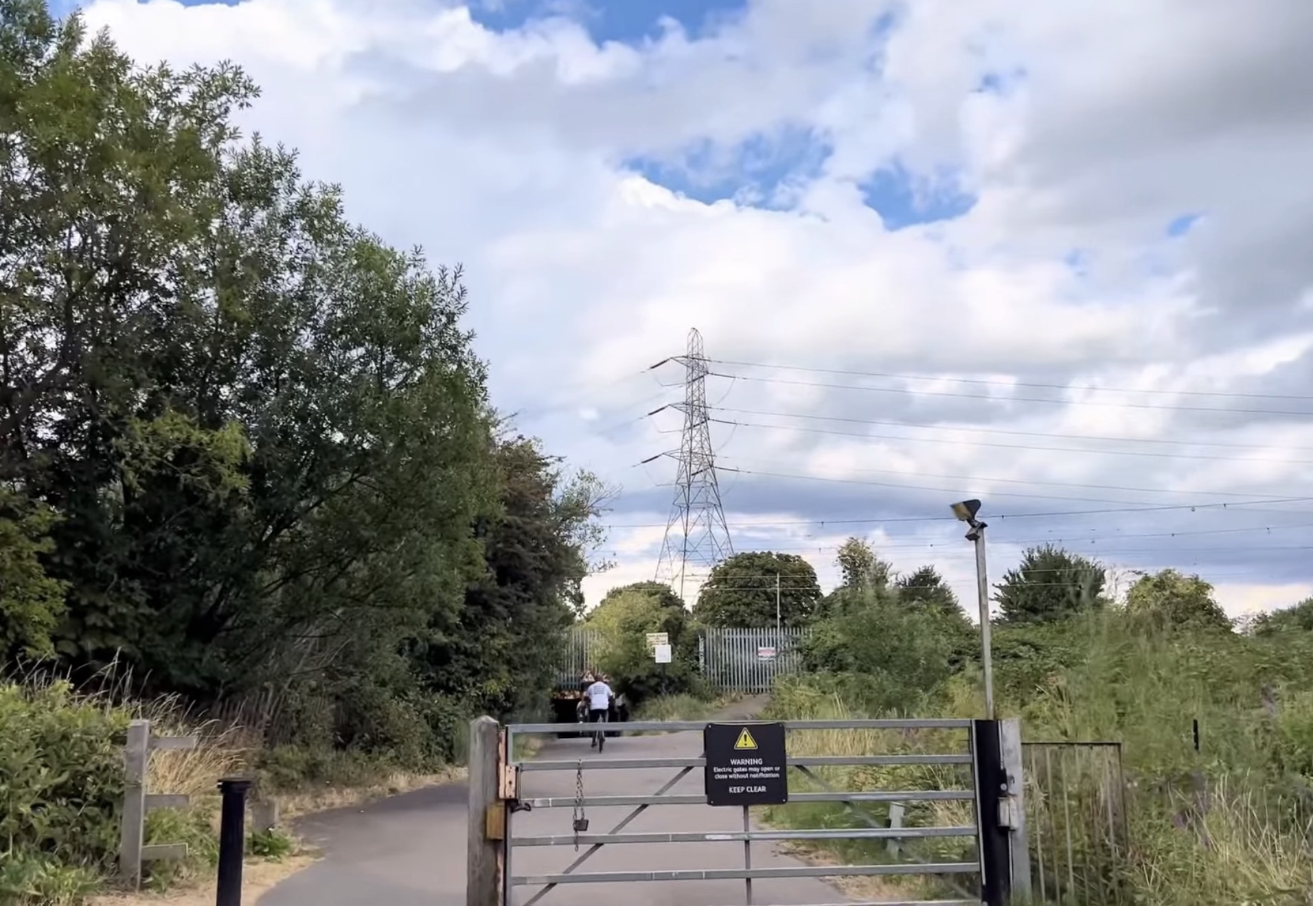 Metal gate on the path into Lee Valley with an electricity pylon beyond