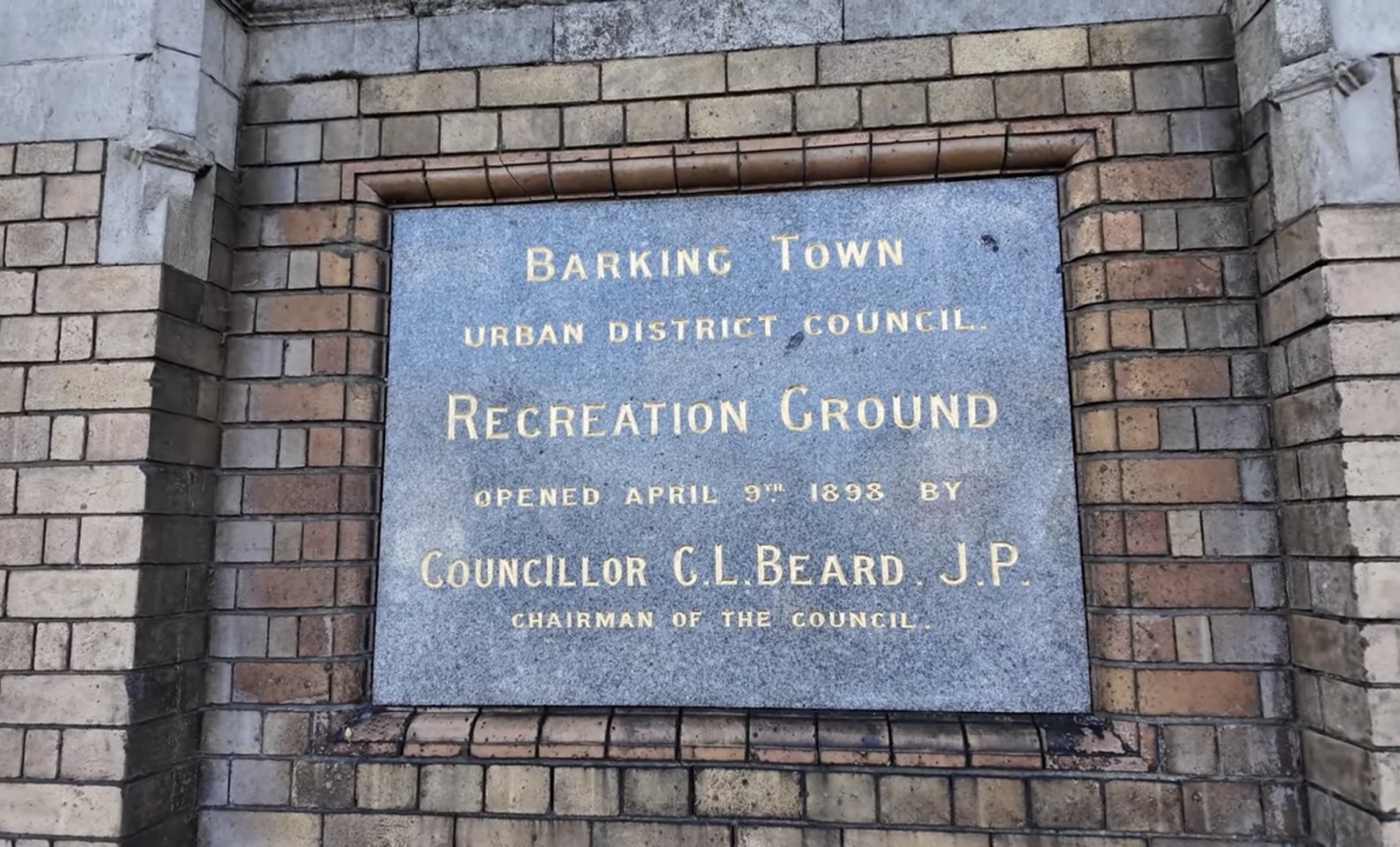 Stone plaque reading Barking Town Urban District Council Recreation Ground, opened April 9th 1898
