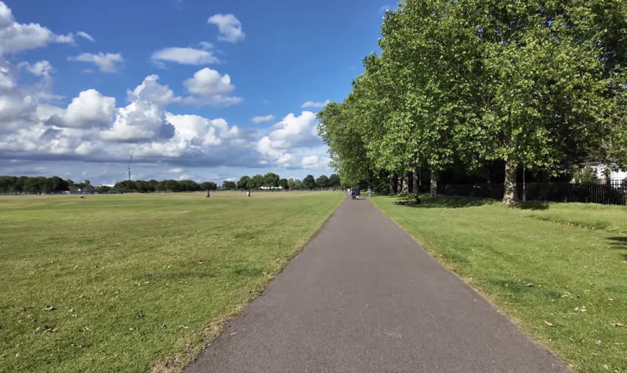 Wide open playing fields in Barking Park with a path running through the middle