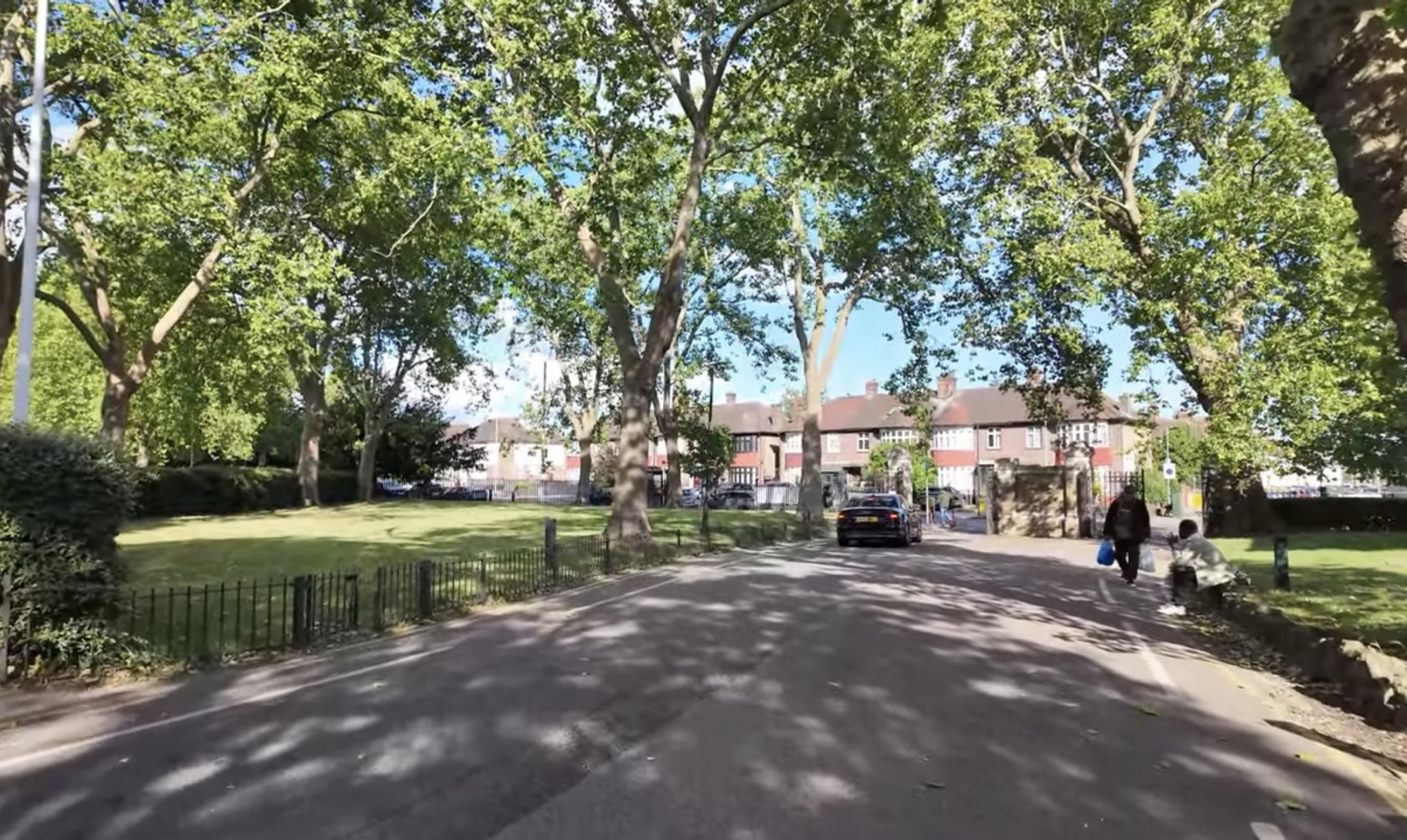 Tree-lined entrance road into Barking Park from Longbridge Road with the stone gate posts