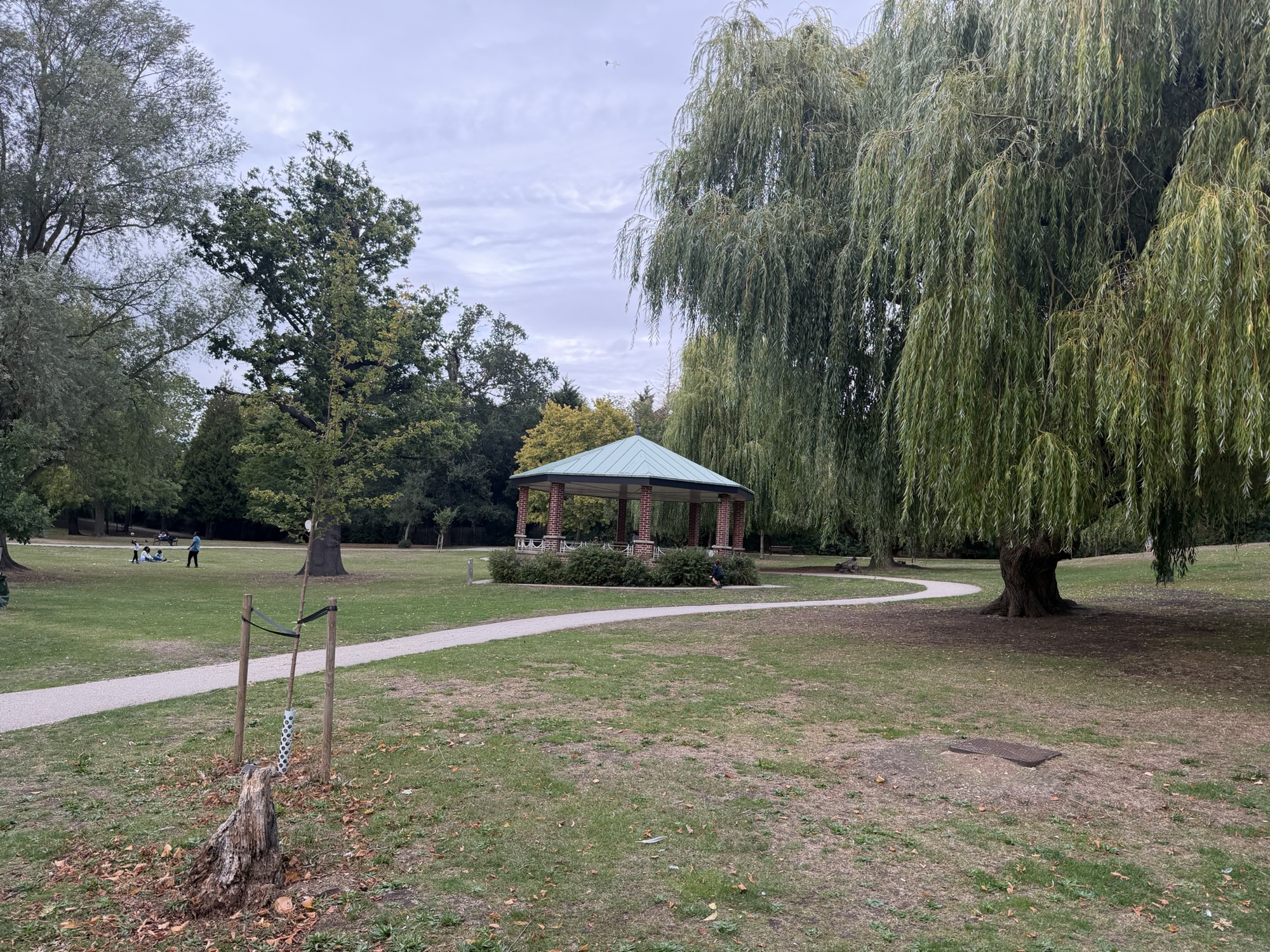 Bandstand with a green roof set among weeping willow trees in Raphael Park