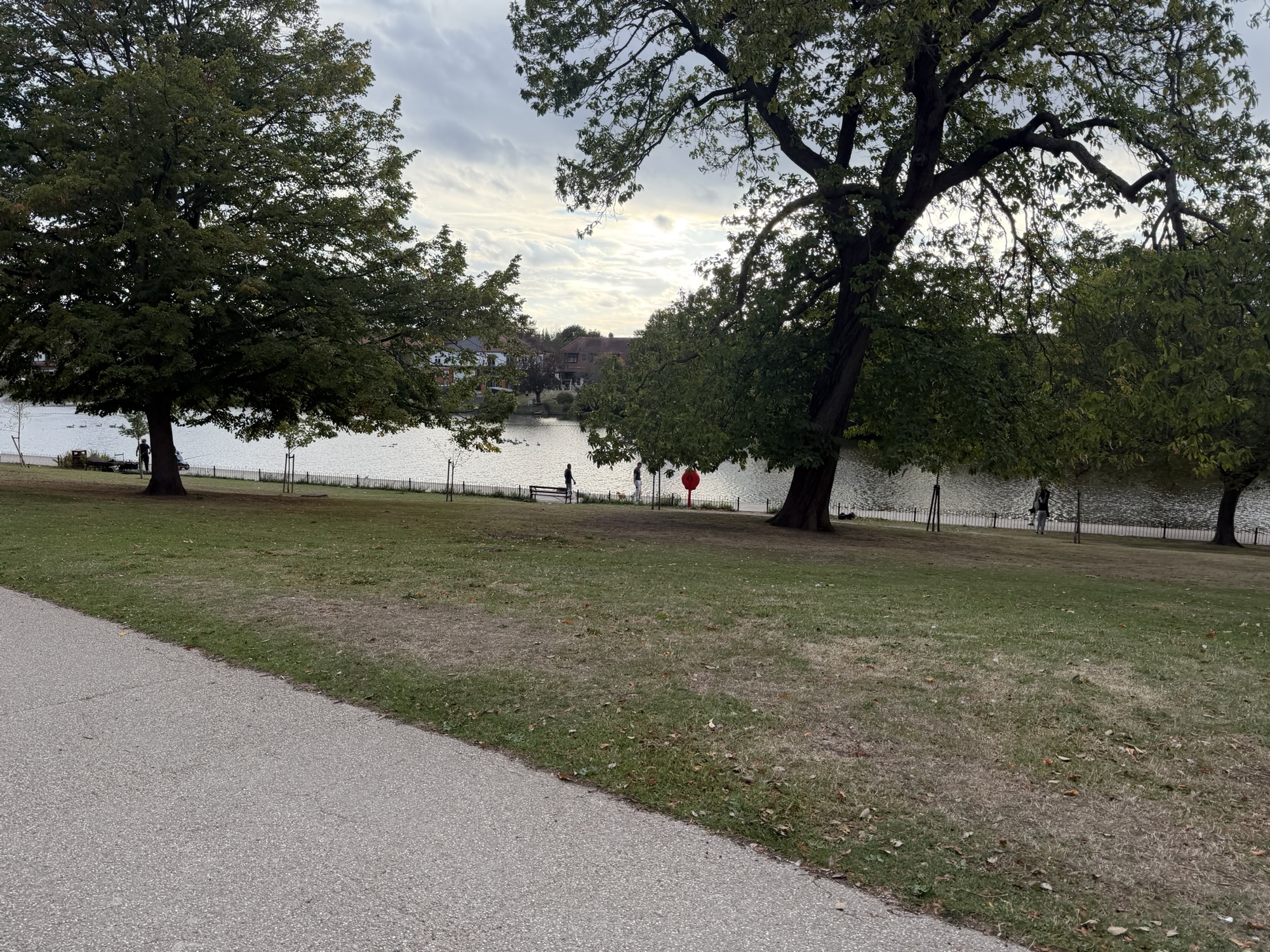 View across the lake in Raphael Park with people fishing on the far bank