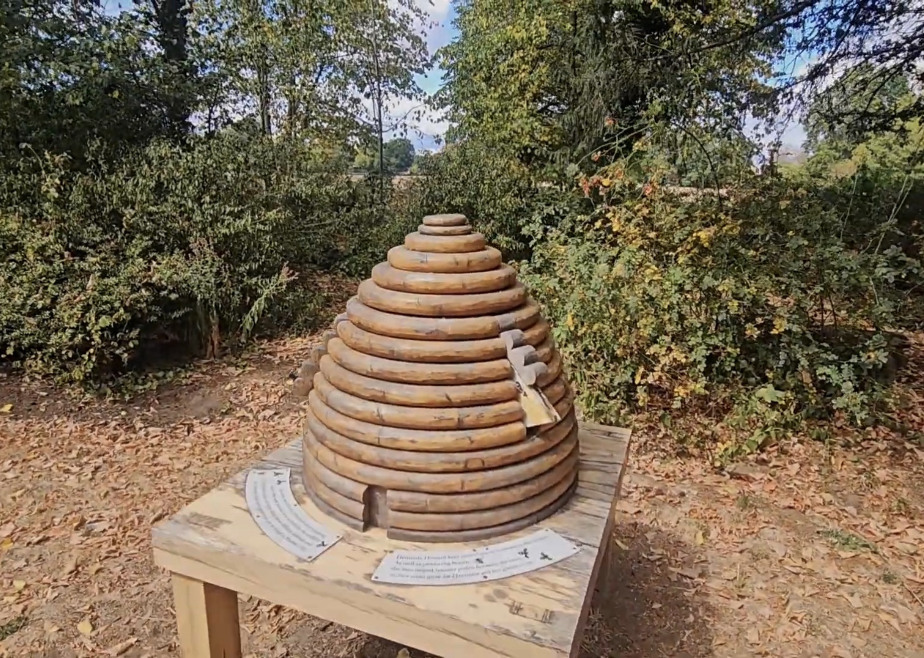 Wooden log-ring sculpture shaped like a traditional bee skep on a table in Marble Hill Park