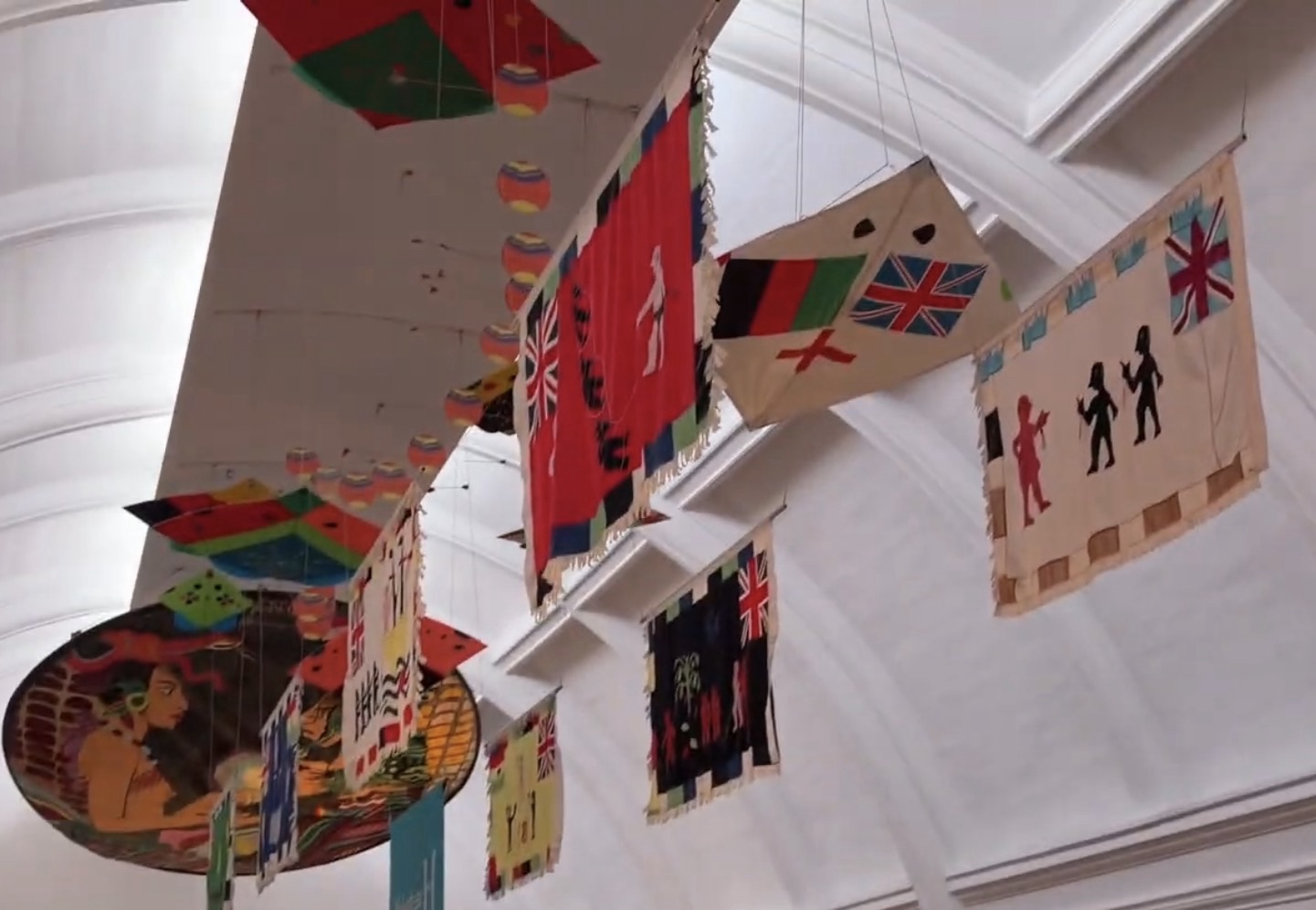 Colourful flags and kites suspended from the ceiling of the World Gallery at the Horniman Museum