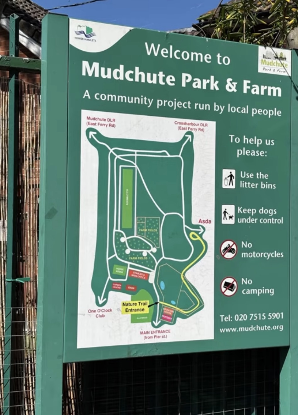 Green welcome board at Mudchute Park and Farm with a site map and park rules