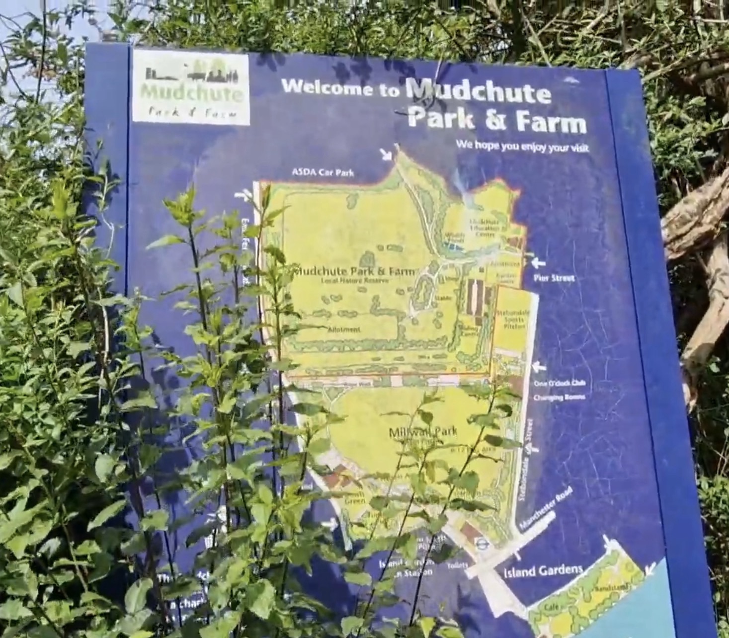 Blue welcome map of Mudchute Park and Farm showing paths, paddocks and facilities