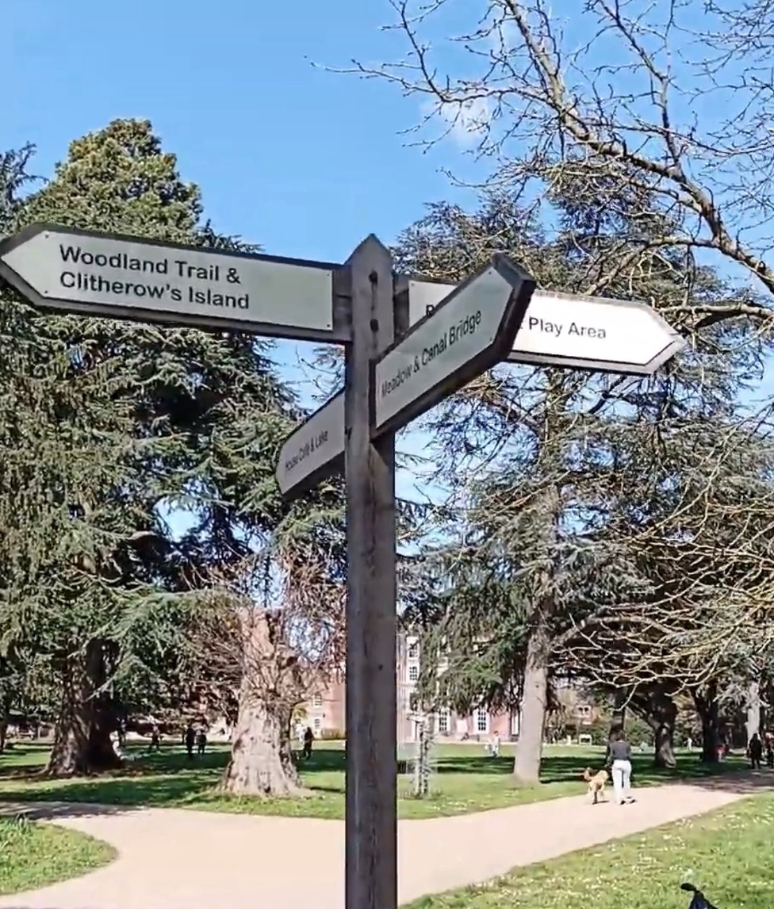 Wooden signpost pointing to Woodland Trail and Clitherow's Island, Meadow and Canal Bridge and the play area